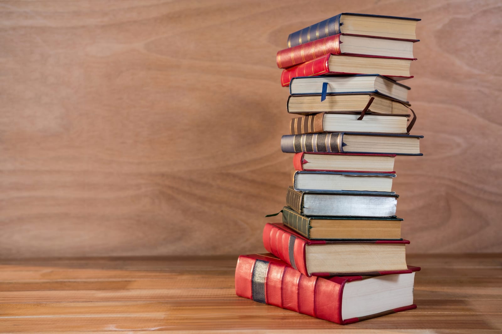 Pilha de livros antigos empilhados sobre uma mesa de madeira